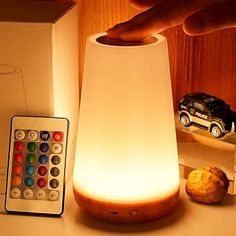 a remote control sitting on top of a table next to a lamp and remote controller