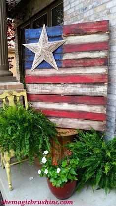 an american flag made out of wood sitting on top of a wooden bench next to potted plants