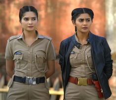 two women in uniform standing next to each other with one woman looking at the camera