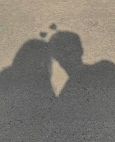 the shadow of two people kissing each other