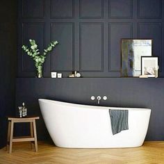 a white bath tub sitting on top of a wooden floor