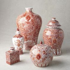 an assortment of vases and jars on a white surface