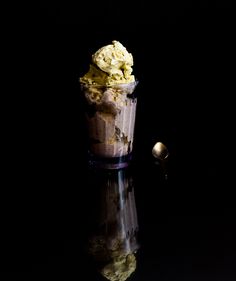 an ice cream sundae in a glass on a reflective surface