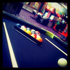 a pool table with cues and balls on it