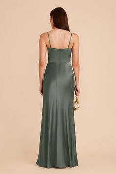 the back of a woman wearing a long green dress with spaghetti straps and low neckline