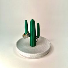 a green cactus ring holder on a white background