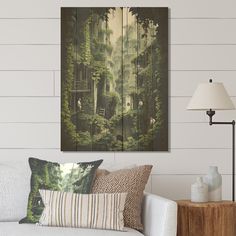 a living room scene with focus on the sofa and wall hangings that have trees painted on them