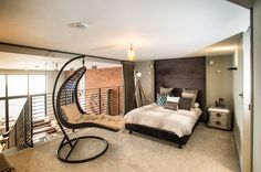 a bedroom with a swing chair and bed in it