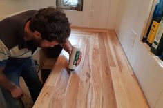 a man sanding down a wooden counter top with a can of kleenex