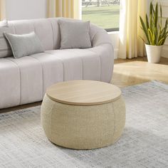 a living room with a couch, chair and coffee table in front of a window