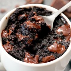 a white cup filled with chocolate pudding on top of a table