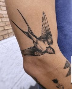 a small bird tattoo on the right arm