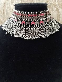 Stand out wearing this striking boho choker in red and soft smokey gray enamel, on oxidized silver so as to create the patina of a vintage tribal piece. Strung on black cotton threads. Maximum length 8 in. Adjustable length using sliding knot, to ensure a perfect fit for you. Wear high up as a choker or lower down, peeking out of a button up shirt. Or on the outside of the shirt. Mesmerizing movement with tiny bells. You will be noticed! And complimented! Shop chokers: https://www.etsy.com/shop/ Traditional Red Choker For Festival, Red Bohemian Choker Necklace, Silver Choker Necklace For Festival, Silver Oxidized Finish Choker For Festivals, Adjustable Festival Choker, Metal Choker With Oxidized Finish, Pink Bohemian Choker For Festivals, Vintage Red Metal Choker, Oxidized Finish Choker Necklaces For Festival