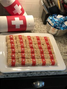 a white plate topped with crackers covered in red and white squares next to a roll of toilet paper