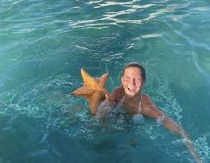 a woman in the water with a starfish