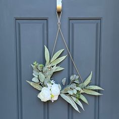 a wreath hanging on the front door with flowers