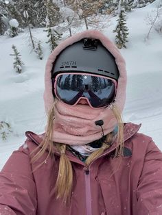 a woman wearing ski goggles and a pink jacket