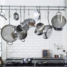 pots and pans hanging from a rack in a kitchen