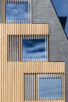 the side of a building with wooden slats on it's sides and blue sky in the background