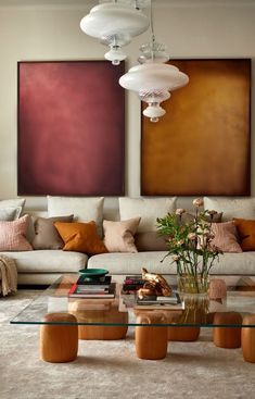 a living room filled with furniture and paintings on the wall above it's coffee table