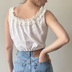 White Vintage Tank Top For Spring, Sleeveless Cotton Eyelet Top, White Sleeveless Top With Eyelet Details, Vintage White Cotton Top For Spring, White Sleeveless Eyelet Top, Vintage Sleeveless Ruffled Tops, Cotton Tops With Crochet Trim For Daywear, Sleeveless Broderie Anglaise Tops For Daywear, Vintage Sleeveless Tops For Daywear