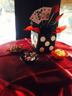 a table topped with plates and cups filled with food next to a vase full of flowers