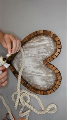 a person cutting rope with scissors on top of a piece of wood