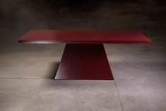 a red table sitting on top of a cement floor