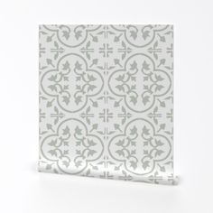 a white and grey tile with an ornate design on it's side, against a white background