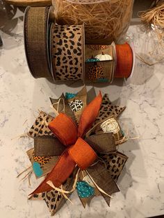 two spools of twine tied together with leopard print and orange ribbon on top