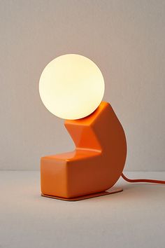 an orange lamp sitting on top of a white table