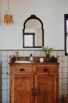 a bathroom with a wooden cabinet and mirror