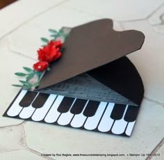 an origami music box with piano keys and flowers