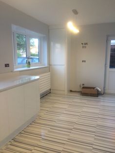 an empty kitchen with white cabinets and counter tops in the middle of the flooring