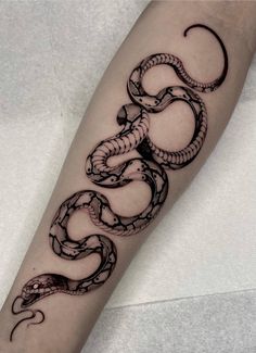 a black and white snake tattoo on the arm