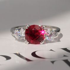 a red ring with three diamonds on it