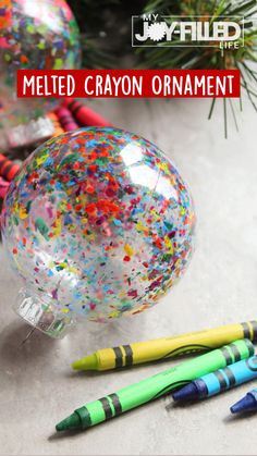 melted crayon ornament next to markers and christmas tree ornaments with text overlay