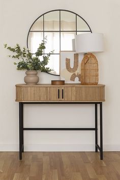 a wooden table topped with a mirror next to a plant