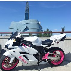 a white and pink motorcycle parked in front of a building