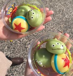 two hands holding small plastic toy balls with faces on them and stars in the middle