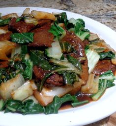 a white plate topped with meat and vegetables