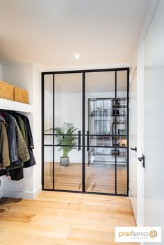 an open closet with clothes hanging on the wall and coat rack in front of it