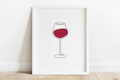 a white frame with a drawing of a glass of red wine on the wall next to it