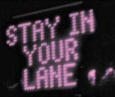 a sign that says stay in your lane on the side of a building with neon lights