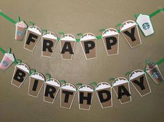 a happy birthday banner with starbucks bags and starbucks coffee cups hanging from it's sides