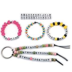 four bracelets with words on them and two keychains attached to each other