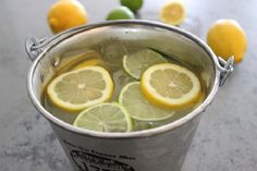 a bucket filled with lemons and limeade sitting on top of a marble counter