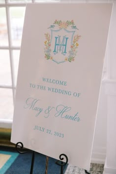 a welcome sign for the bride and groom in front of a window with white curtains