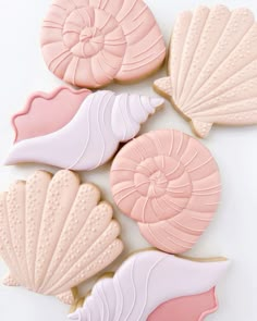 some cookies that are shaped like seashells on top of each other and have pink icing