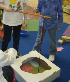 two children are playing with an object in a play room while another child looks on